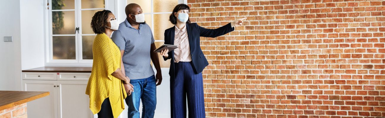 real-estate-agent-and-customer-in-face-mask-looking-at-new-project